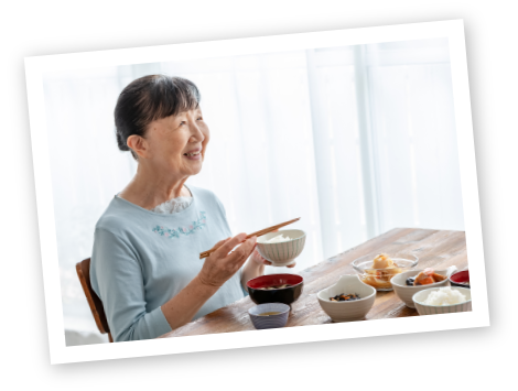 食事をしながら微笑む高齢女性